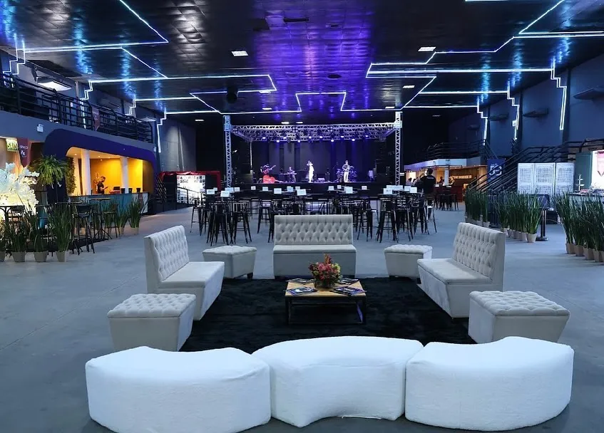 Lounge com sofás brancos em frente ao palco com banda ao vivo na Luna Live